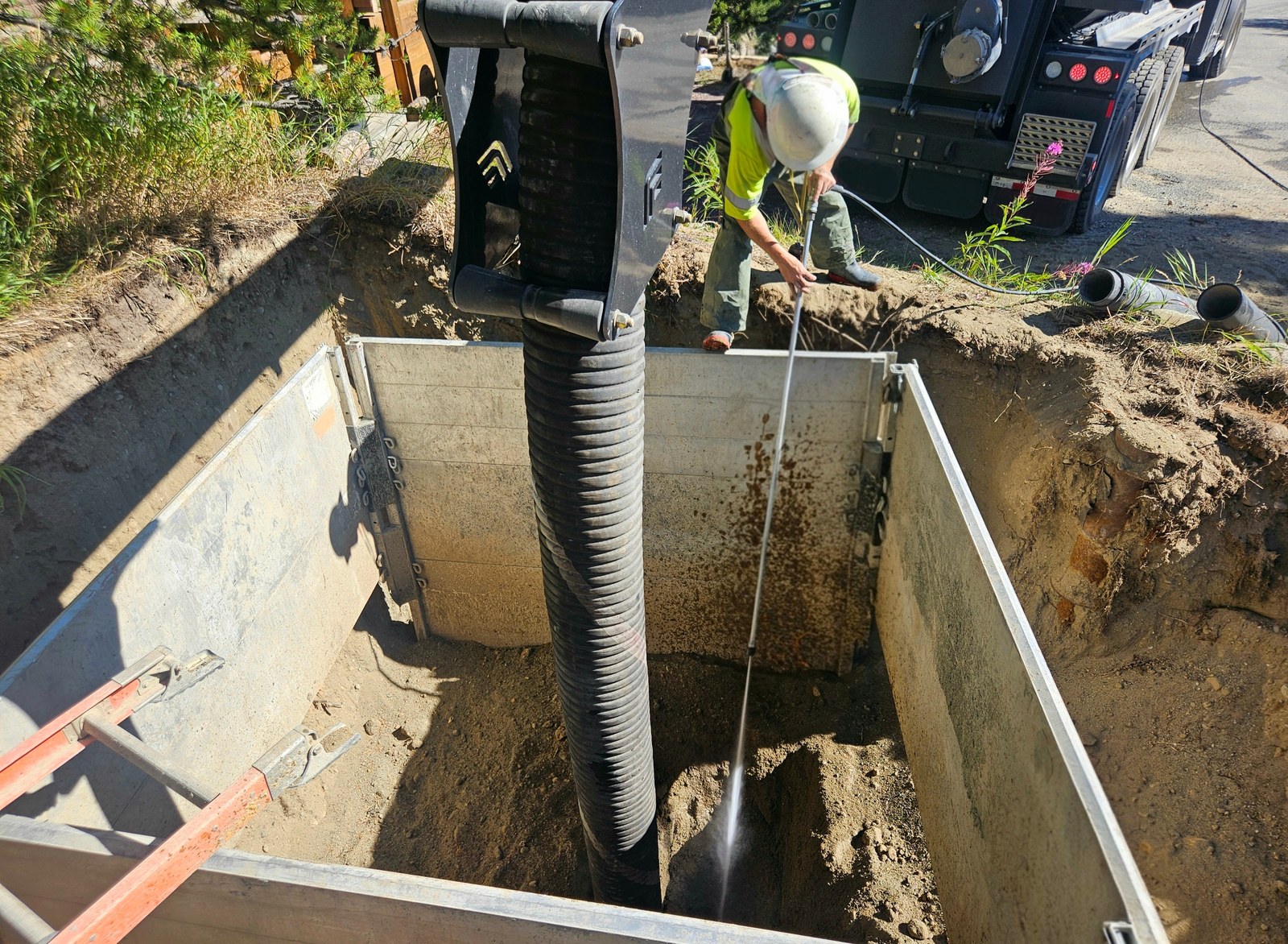 Water wand exposing buried utilities in a shored hydrovac excavation trench